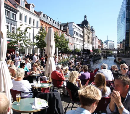Mennesker på caféer langs åen i Aarhus en solskinsdag
